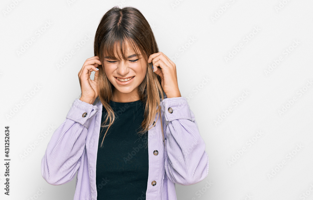 Teenager caucasian girl wearing casual clothes covering ears with fingers with annoyed expression for the noise of loud music. deaf concept. Teenager caucasian girl wearing casual clothes covering ears with fingers with annoyed expression for the noise of loud music. deaf concept.