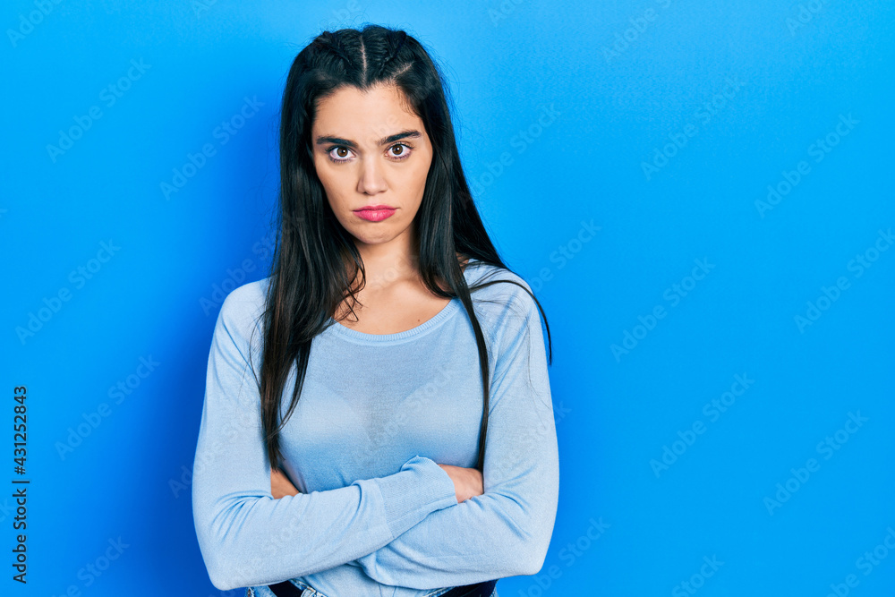 Young hispanic girl wearing casual clothes skeptic and nervous, disapproving expression on face with crossed arms. negative person. Young hispanic girl wearing casual clothes skeptic and nervous, disapproving expression on face with crossed arms. negative person.