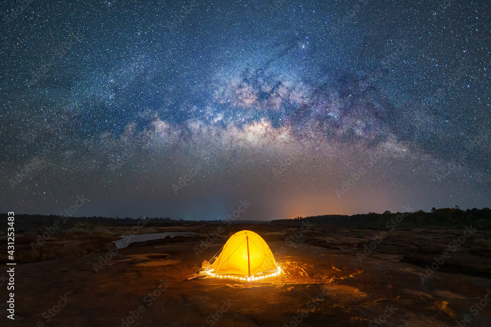 Camping tent under sky on mountain hills with the milky way with bright  stars at night in travel on holiday vacation concept. Natural universe  space landscape background. Adventure tourist activity. Stock Photo