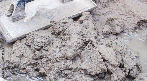 Cimento, Concreto. Carrinho de mão com mistura de cimento e areia e uma desempenadeira. Fotografia em close up. Obra, Construção, Reforma, objetos. photo