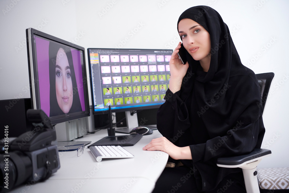 Muslim female graphic designer talking on the phone Muslim female graphic designer talking on the phone