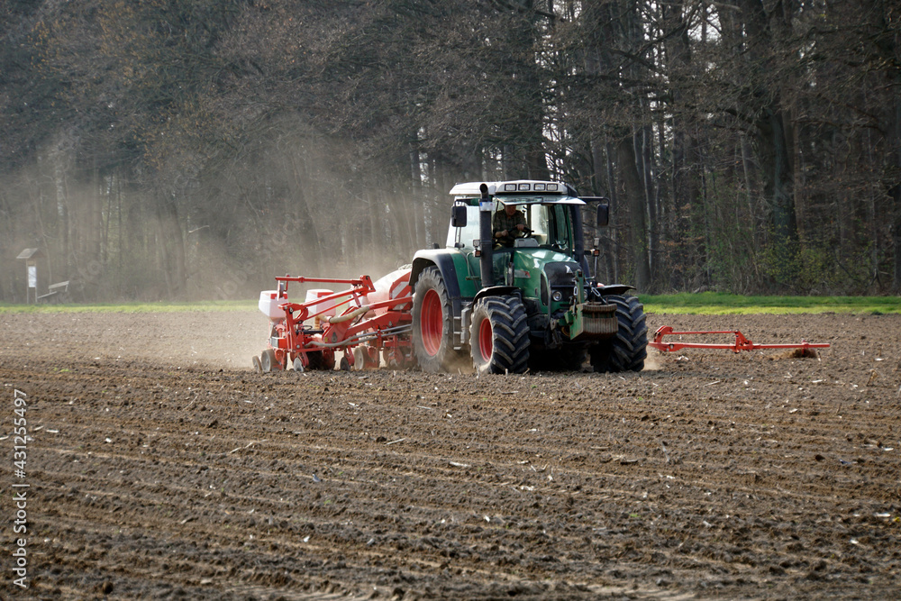 Fototapeta premium Landwirt bearbeitet mit einer Einkorn-Sämaschine das Feld - Farmer works the field with a einkorn seed drill