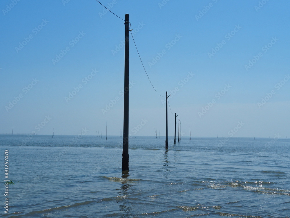 海に沈む道路と電柱