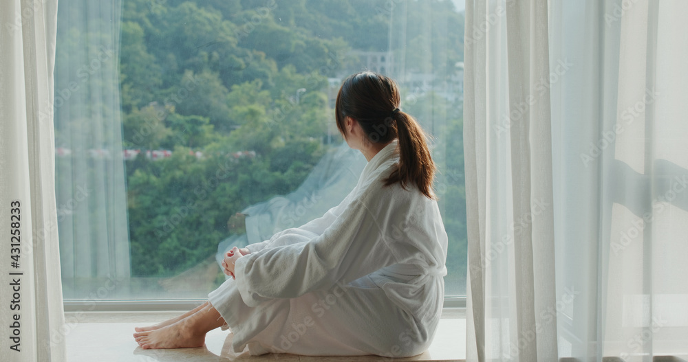 Woman look outside the window at hotel room Woman look outside the window at hotel room