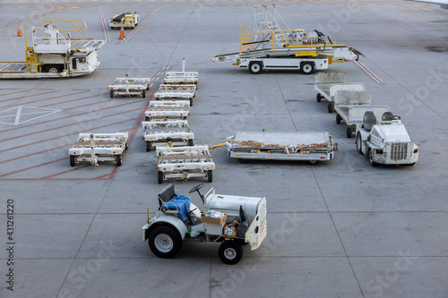 Freight trolleys on the runway of cargo to the commercial airplane.