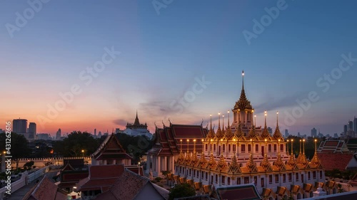 Loha Prasat or Iron Castle Monastery at Wat Ratchanatdaram temple, on Ratchadamnoen Avenue during morning, Bangkok, Thailand; night to day, zoom out – time lapse photo