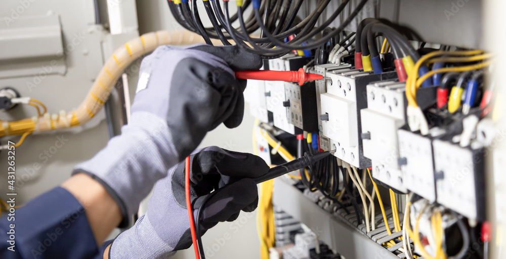 Electrician engineer tests electrical installations and wires on relay ...
