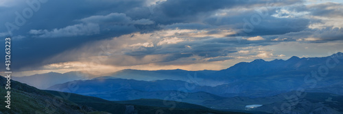 Rainy weather in the mountains, evening light. Panoramic view.
