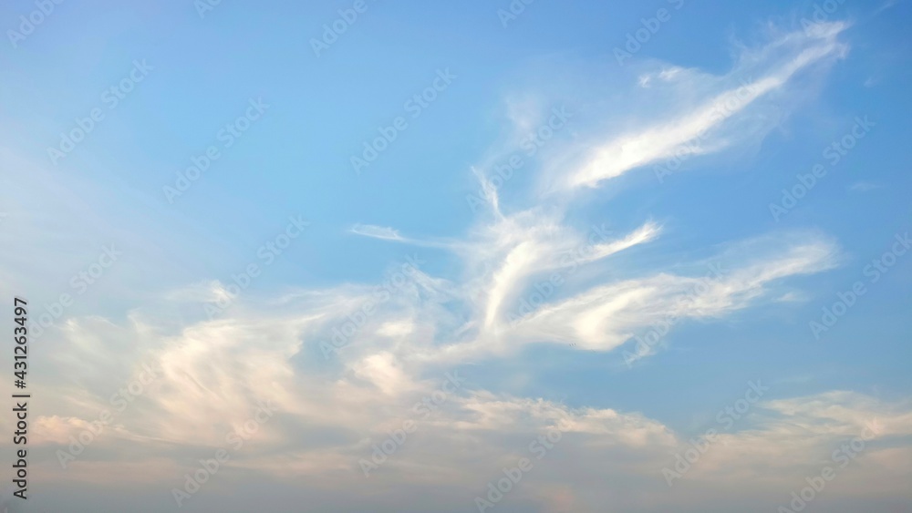 Streak of white clouds on the blue sky. Light clouds in the afternoon reflecting the beautiful sunlight. Streak of white clouds on the blue sky. Light clouds in the afternoon reflecting the beautiful sunlight.
