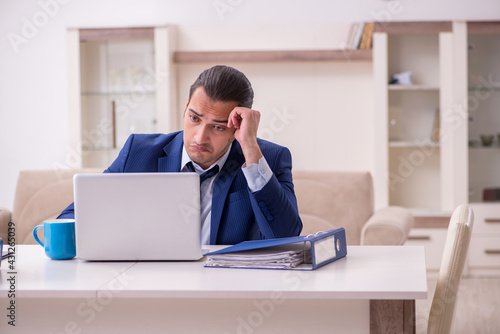 Young male employee working from home in pandemic concept