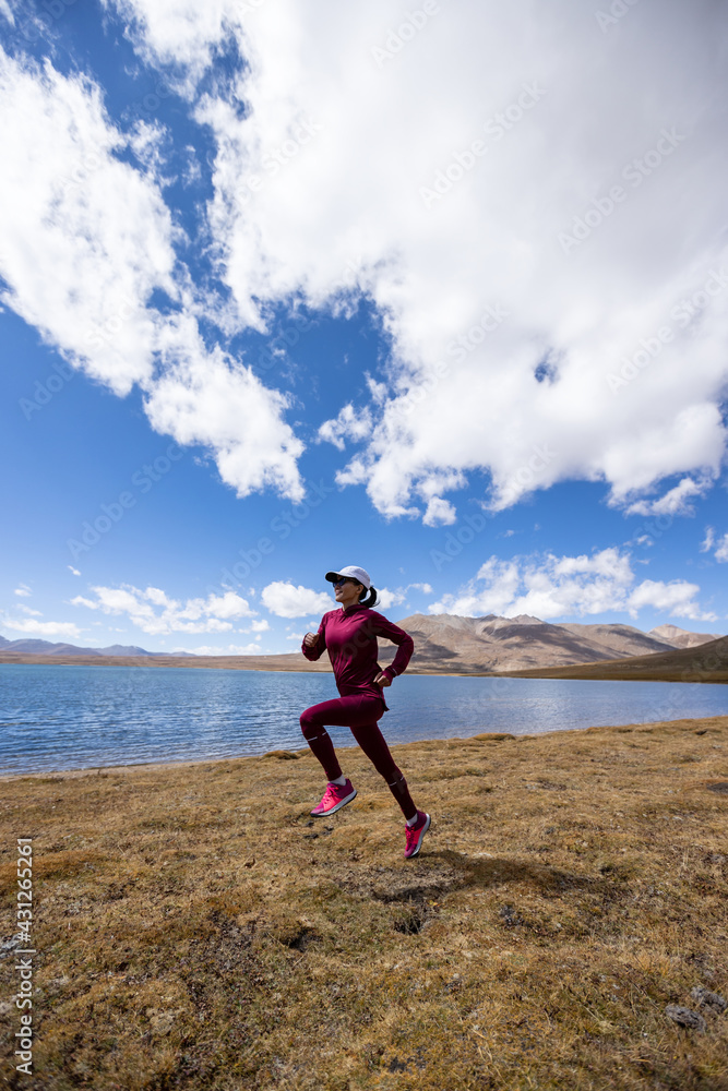 Woman trail runner cross country running on winter lakeside