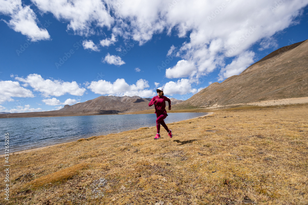 Woman trail runner cross country running on winter lakeside