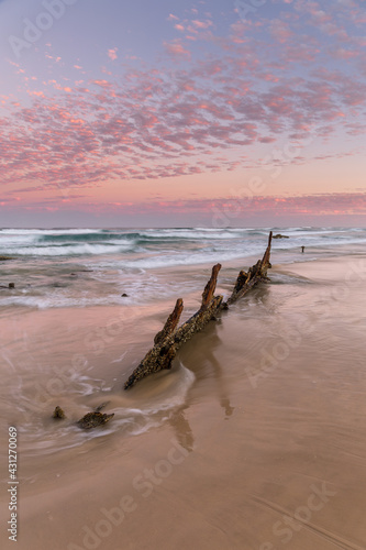 Rusting remains of ship wreck awash on the beach at sunset © Stephen Browne