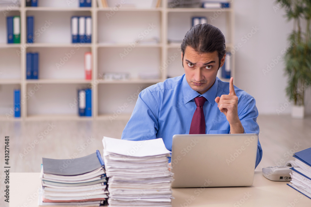 Young male employee unhappy with excessive work Young male employee unhappy with excessive work