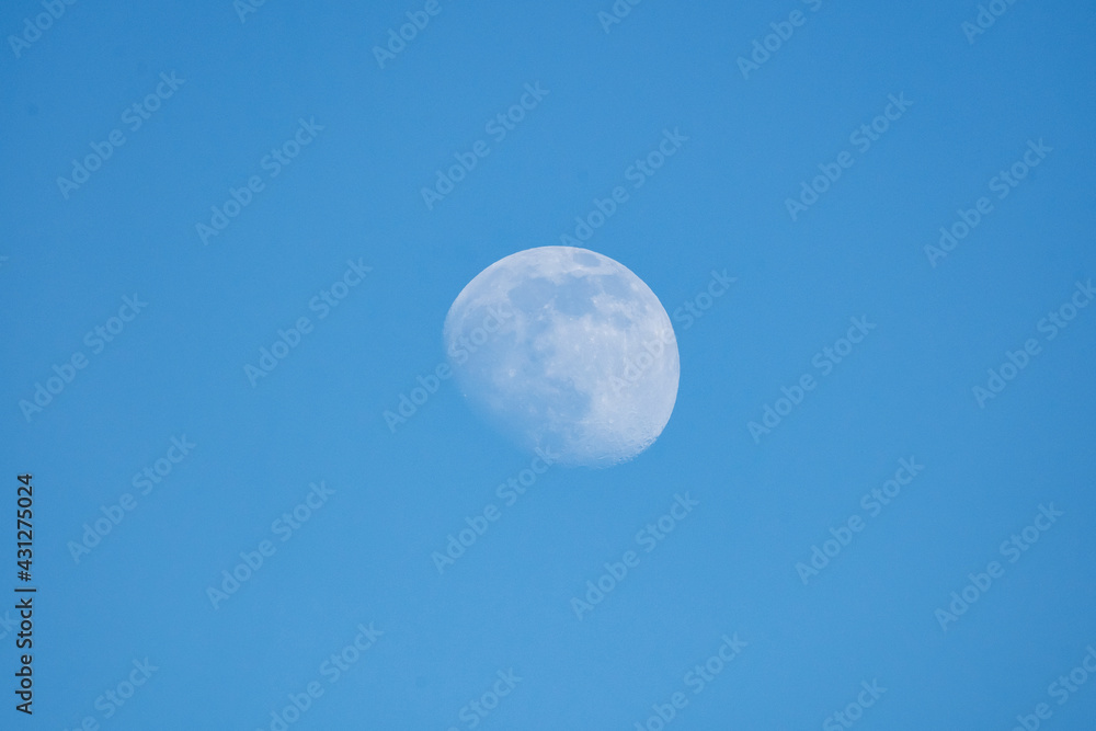 Moon poking through the bright blue day time sky in northern Canada, Yukon Territory. Moon poking through the bright blue day time sky in northern Canada, Yukon Territory.