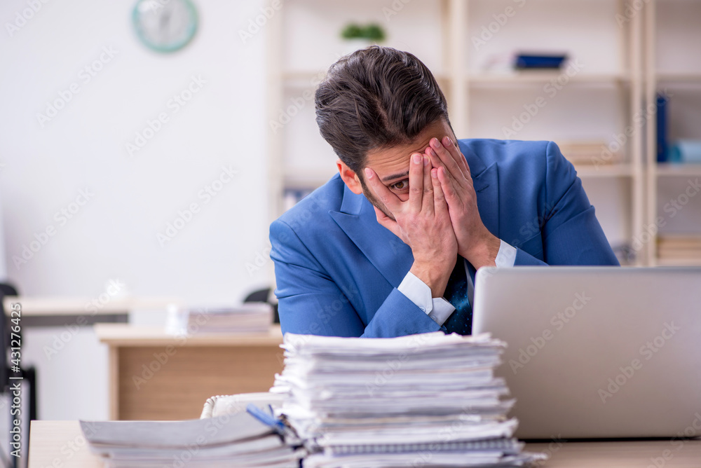 Young businessman employee and too much work in the office Young businessman employee and too much work in the office