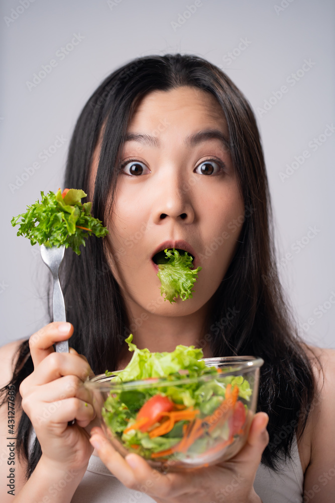 First impression Asian woman eating salad. First impression Asian woman eating salad.