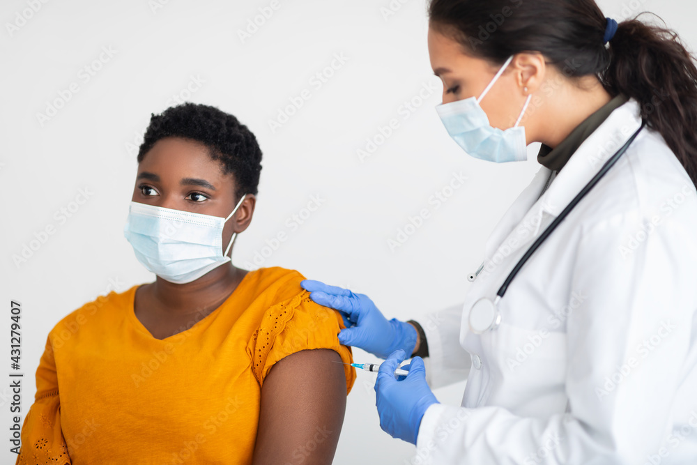 Black Woman In Mask Getting Coronavirus Vaccine Shot, White Background