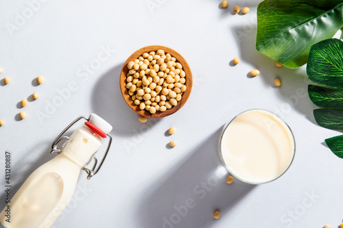 Vegan Soy milk and bean on gray table background. Non dairy milk concept. Diet drink. Hard light. Copy space photo