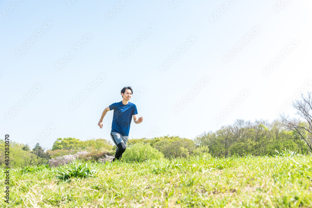 公園でランニングをする若い男性