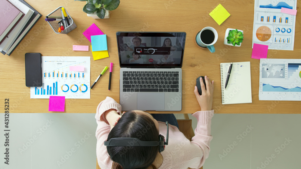 Overhead top view young asian woman employee work from home using computer notebook videocall meeting conference angry annoy with low poor unreliable internet wifi connection problem issue outage. Overhead top view young asian woman employee work from home using computer notebook videocall meeting conference angry annoy with low poor unreliable internet wifi connection problem issue outage.