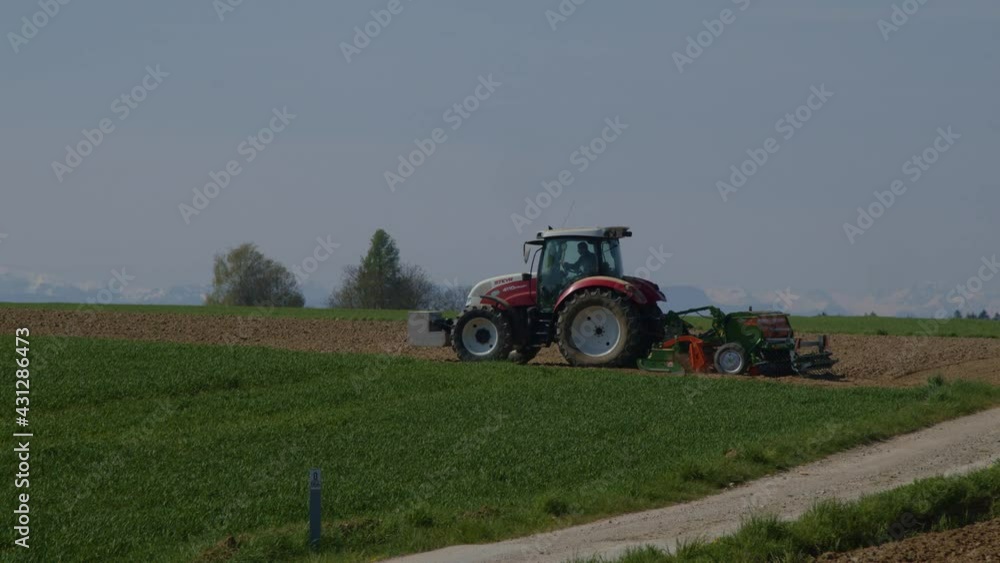tractor with seeder on agricultural field in spring tractor with seeder on agricultural field in spring