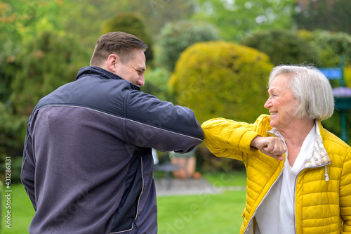 Grandmother greeting her grandson using her elbow during the Covid-19 pandemic photo