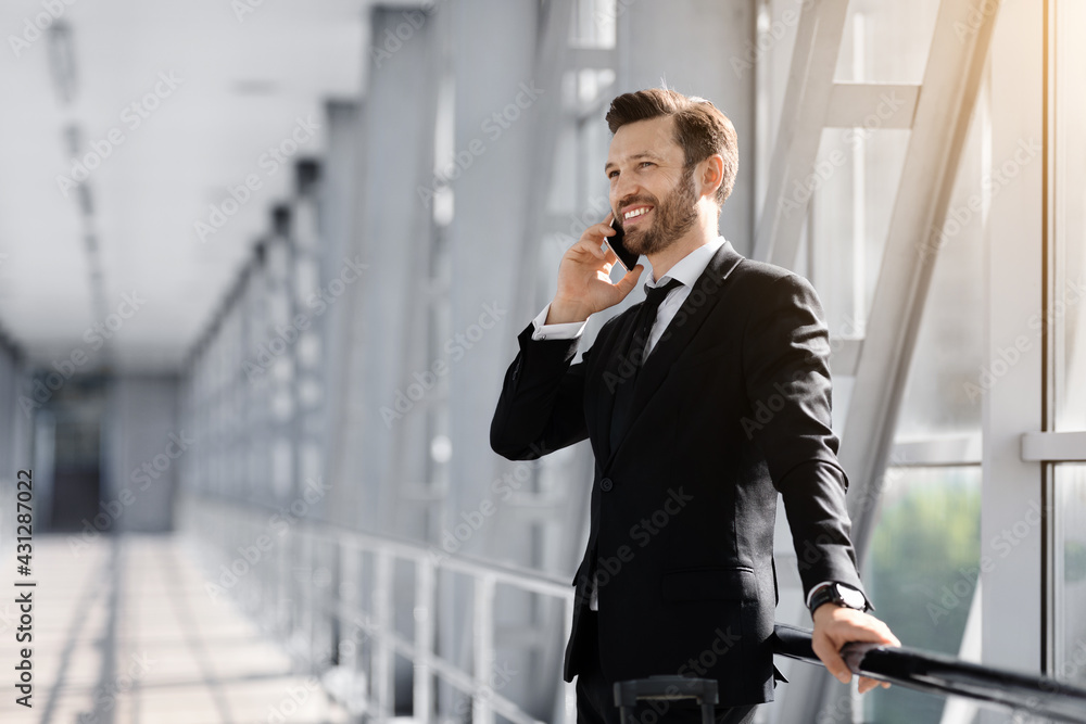 Handsome middle-aged businessman talking on phone in airport Handsome middle-aged businessman talking on phone in airport