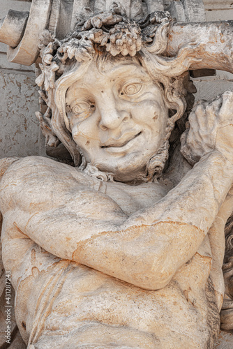 Ancient sculpture of funny, tricky and joyful dickens in historical downtown of Dresden, Germany, details, closeup. Concept of art and historical heritage.