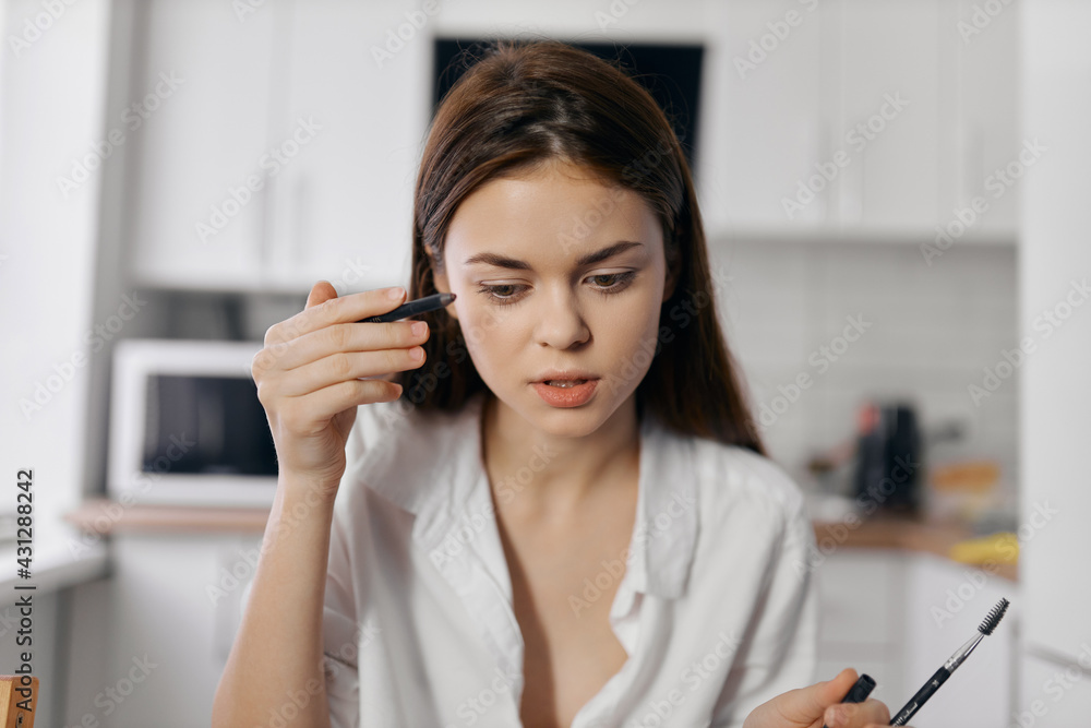 woman model with eyeliner pencil in hand woman model with eyeliner pencil in hand
