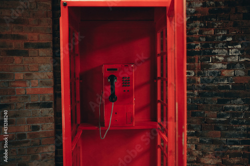 Old school red payphone inside vintage red telephone booth