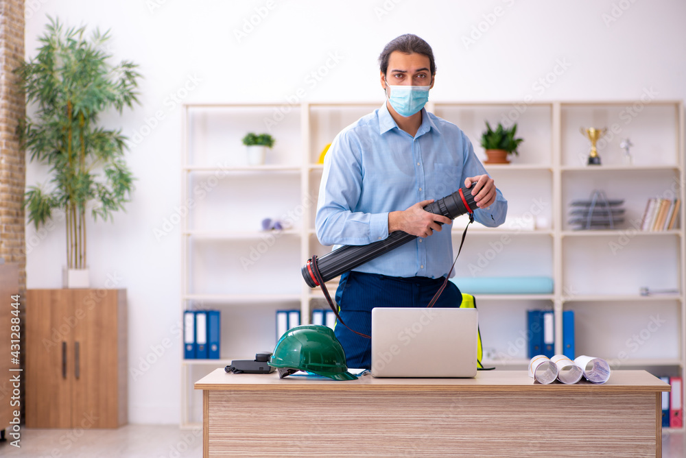 Young male architect working in the office during pandemic Young male architect working in the office during pandemic