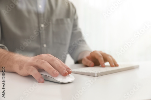 Man using computer mouse at desk  closeup