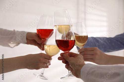 People clinking glasses of wine on white background, closeup