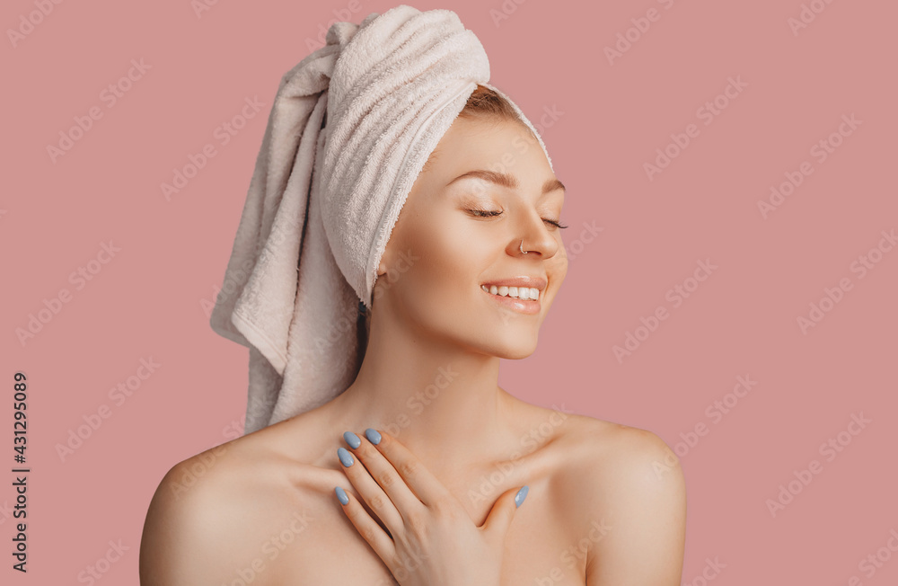 Beautiful sensual young girl with clean skin on a pink background with a mockup. Topless woman in a towel. The concept of spa treatments, natural beauty and care, youth, cream and mask, freshness Beautiful sensual young girl with clean skin on a pink background with a mockup. Topless woman in a towel. The concept of spa treatments, natural beauty and care, youth, cream and mask, freshness