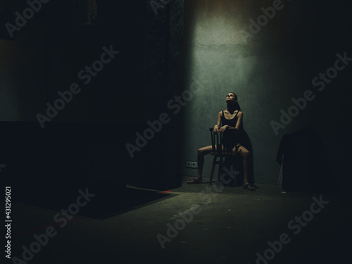 woman sitting on a chair leaning against a wall indoors loneliness depression conflict
