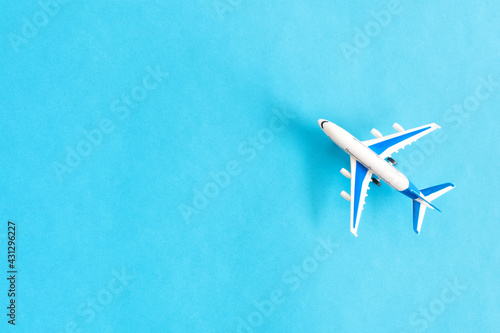 Top view of small toy plane. Aviation Solutions concept. On pastel light blue background.