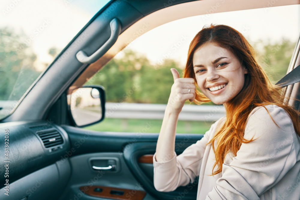 happy woman in sweater driving on the front seat of a car clean interior design model