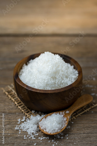 Natural salt in a wooden cup On the wooden table Ready to cook.