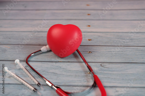 Medical red heart on wooden background © stang