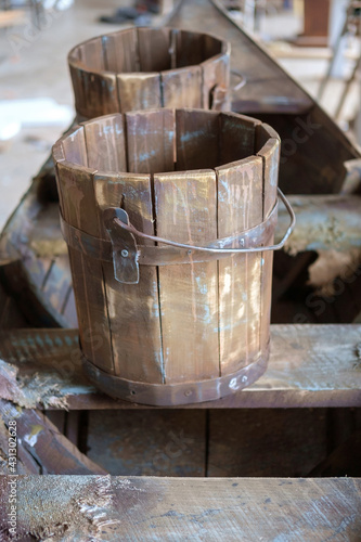 Old wooden buckets on wooden surface, selective focus © Luka