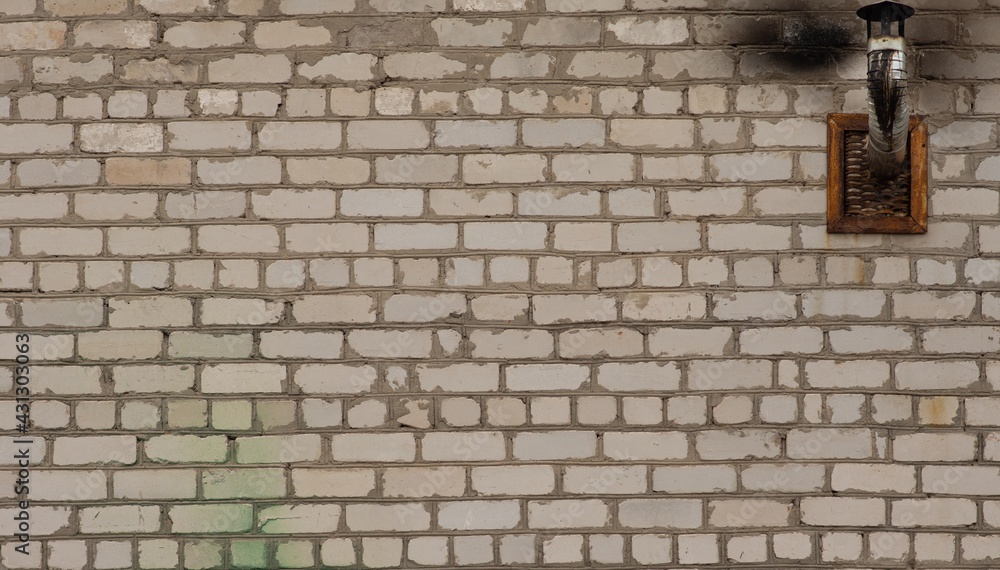 An old white brick wall with a chimney. Part of the wall was blackened by the smoke. An old white brick wall with a chimney. Part of the wall was blackened by the smoke.