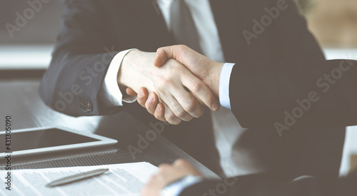Wallpaper Mural Unknown businessmen shaking hands above the glass desk in a modern office, close-up. Unknown business people at meeting. Teamwork, partnership and handshake concept Torontodigital.ca