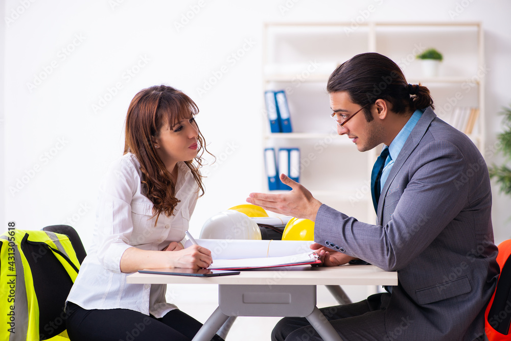 Young businessman and female architect discussing new project Young businessman and female architect discussing new project