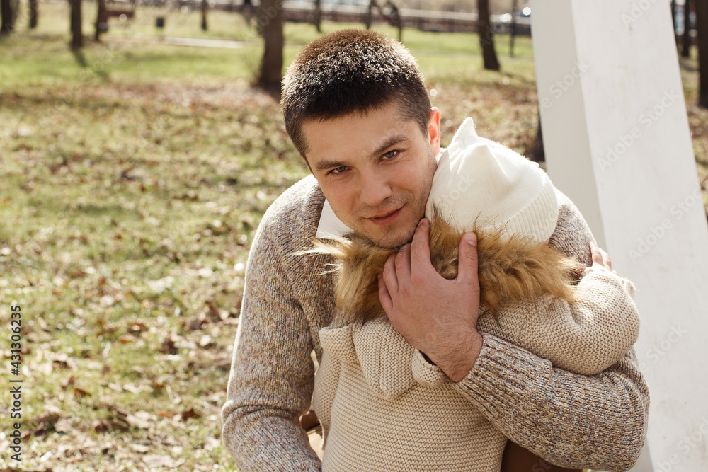 A young, handsome father walks with his little daughter in the park. Happy baby with dad. A young, handsome father walks with his little daughter in the park. Happy baby with dad.
