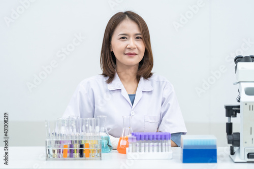 A young woman researcher  doctor  scientist  or laboratory assistant working with plastic medical tubes to research  examine scientific experiments in a modern laboratory. Education stock photo