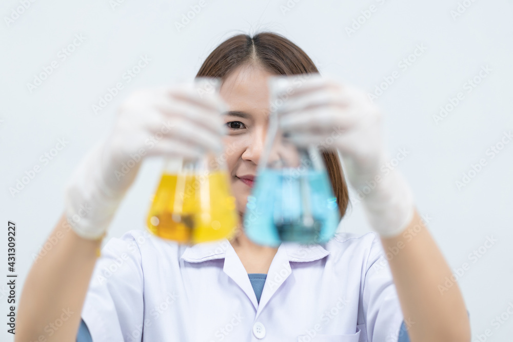 A young woman researcher, doctor, scientist, or laboratory assistant working with plastic medical tubes to research, examine scientific experiments in a modern laboratory. Education stock photo A young woman researcher, doctor, scientist, or laboratory assistant working with plastic medical tubes to research, examine scientific experiments in a modern laboratory. Education stock photo