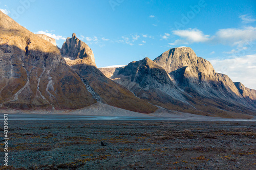 Sunset at the end of a sunny summer day in a remote arctic valley of Akshayuk Pass, Baffin Island, Canada. Last rays of sunlight light up surrounding peaks © Petr