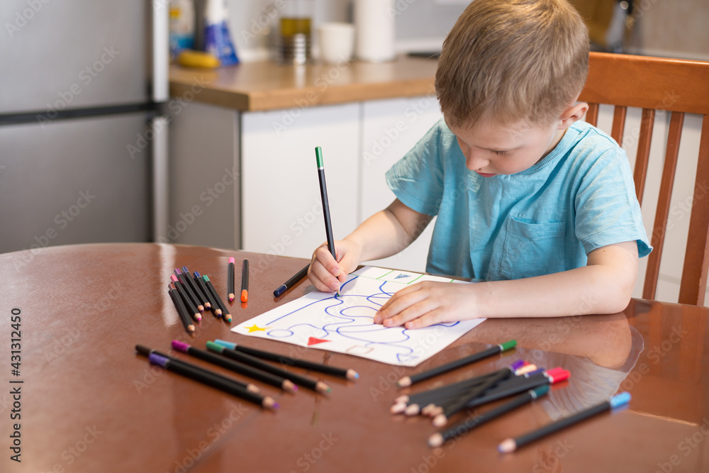The child boy does tasks for the development of logical thinking, classes with a speech therapist at home, neuropsychology, autism, homework. The child boy does tasks for the development of logical thinking, classes with a speech therapist at home, neuropsychology, autism, homework.