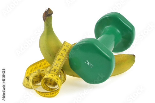 Concept de régime banane avec un haltère et un mètre souple en gros plan sur fond blanc